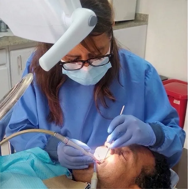 Odontóloga tratando a un paciente en el sillón dental